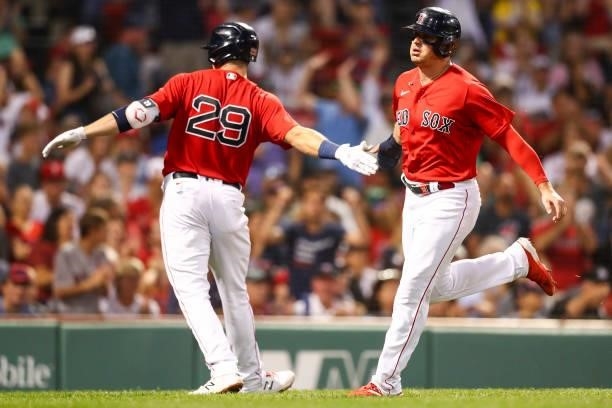 Hunter Renfroe high fives Bobby Dalbec of the Boston Red Sox after scoring in the third inning of a game against the Philadelphia Phillies at Fenway...