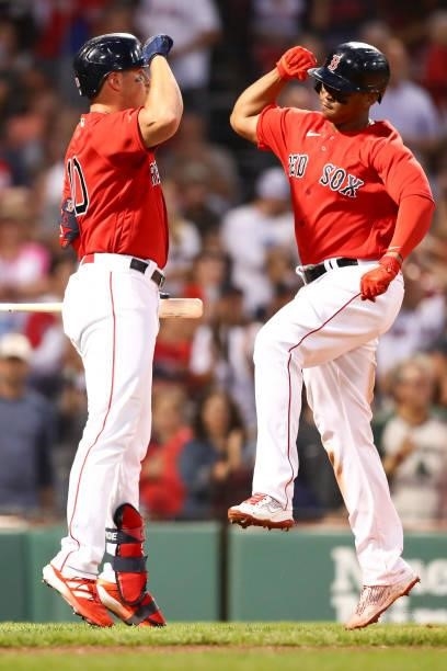 Rafael Devers reacts with Hunter Renfroe of the Boston Red Sox after hitting a solo home run in the third inning of a game against the Philadelphia...
