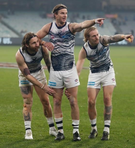 Lachie Henderson of the Cats prepares to be chaired from the field after his 200th match by teammates Zach Tuohy and Tom Stewart during the 2021 AFL...