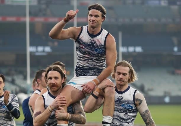 Lachie Henderson of the Cats is chaired from the field after his 200th match by teammates Zach Tuohy and Tom Stewart during the 2021 AFL Round 17...