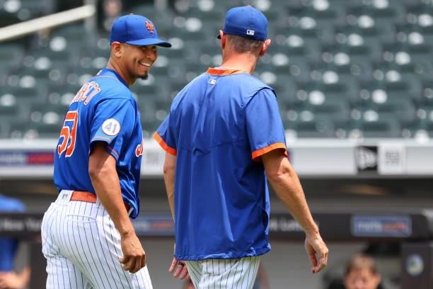 Pitcher Carlos Carrasco of the New York Mets talks to pitching coach Jeremy Hefner after throwing off the mound to live batters before game one of a...