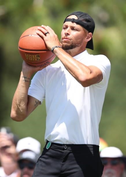 Athlete Steph Curry shoots a basketball on the 17th hole during round two of the American Century Championship at Edgewood Tahoe South golf course on...