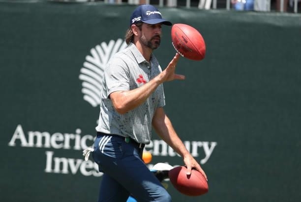 Athlete Aaron Rodgers throws a football on the 17th hole during round two of the American Century Championship at Edgewood Tahoe South golf course on...