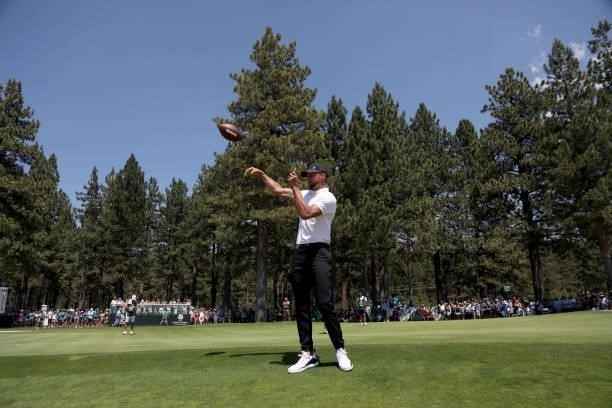 Athlete Steph Curry throws a football on the 17th hole during round two of the American Century Championship at Edgewood Tahoe South golf course on...