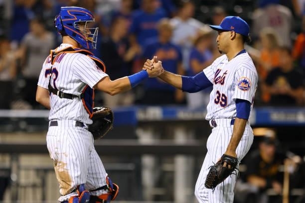 Catcher James McCann of the New York Mets shakes hands with closer Edwin Diaz after Diaz struck out the side in the ninth inning against the...