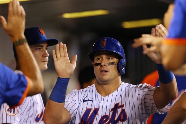 James McCann of the New York Mets is congratulated by teammates in the dugout after scoring on a single by Billy McKinney in the sixth inning against...