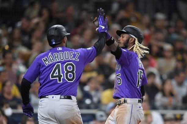 Raimel Tapia of the Colorado Rockies is congratulated by German Marquez after scoring during the fifth inning of a baseball game against the San...