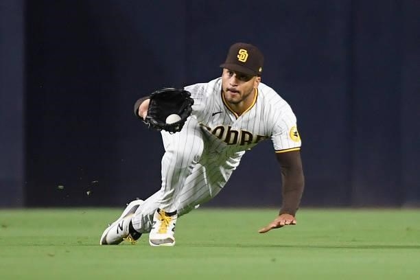 Trent Grisham of the San Diego Padres makes a diving catch on a ball hit by Dom Nunez of the Colorado Rockies during the sixth inning of a baseball...
