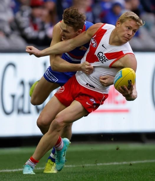 Bailey Dale of the Bulldogs tackles Isaac Heeney of the Swans during the 2021 AFL Round 17 match between the Western Bulldogs and the Sydney Swans at...