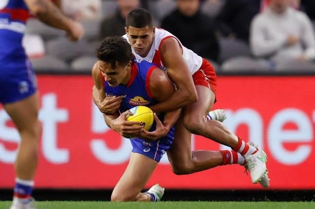 Jamarra Ugle-Hagan of the Bulldogs is tackled by James Bell of the Swans during the 2021 AFL Round 17 match between the Western Bulldogs and the...