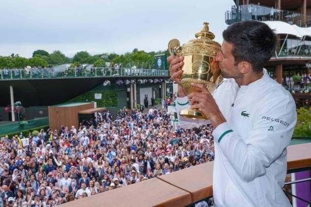 Spectators cheer as Serbia's Novak Djokovic kisses the winner's trophy on the balcony of the Clubhouse after defeating Italy's Matteo Berrettini...