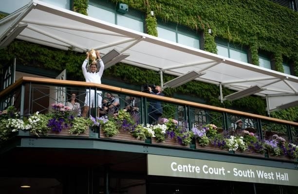 Serbia's Novak Djokovic holds the winner's trophy on the Players Balcony after defeating Italy's Matteo Berrettini during their men's singles final...