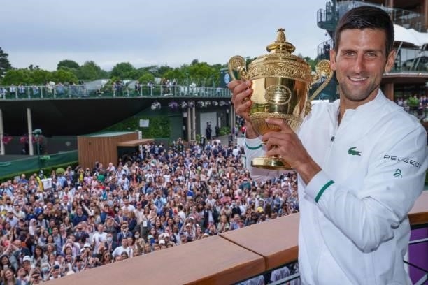 Spectators cheer as Serbia's Novak Djokovic poses with the winner's trophy on the balcony of the Clubhouse after defeating Italy's Matteo Berrettini...
