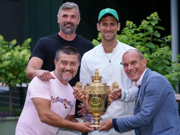 Serbia's Novak Djokovic and his team, including coach Goran Ivanisevic , Edoardo Artaldi , and Ulises Badio, pose with the winner's trophy on the...