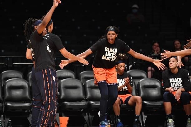 Jonquel Jones of the Connecticut Sun high fives teammates before the game against the New York Liberty on July 11, 2021 at the Barclays Center in...