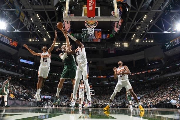 Deandre Ayton of the Phoenix Suns, Brook Lopez of the Milwaukee Bucks and Cameron Payne of the Phoenix Suns fight for the rebound during Game Three...