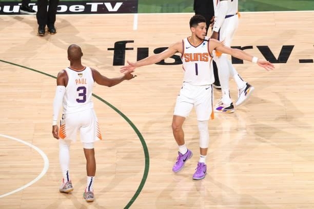Devin Booker of the Phoenix Suns high-fives teammate Chris Paul during the game against the Milwaukee Bucks during Game Three of the 2021 NBA Finals...