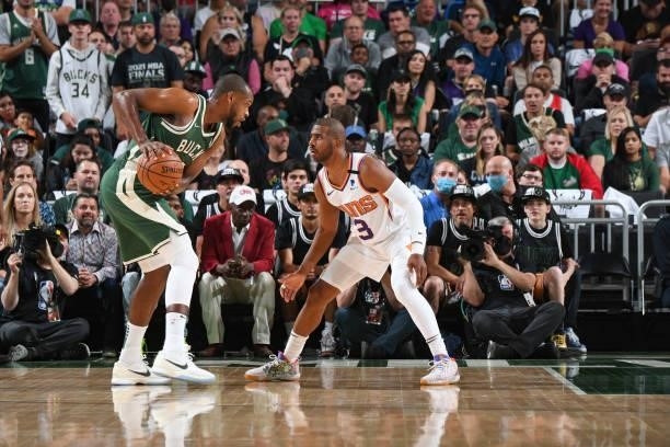 Khris Middleton of the Milwaukee Bucks handles the ball as Chris Paul of the Phoenix Suns plays defense during Game Three of the 2021 NBA Finals on...