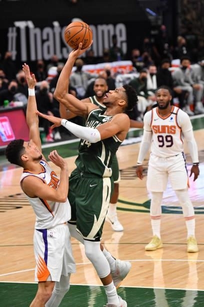 Giannis Antetokounmpo of the Milwaukee Bucks shoots the ball against Devin Booker of the Phoenix Suns during Game Three of the 2021 NBA Finals on...