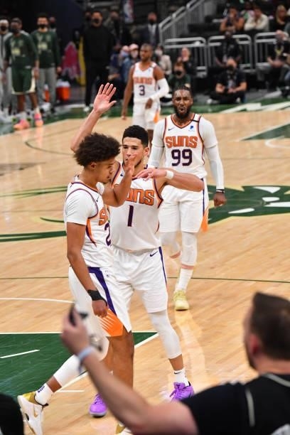 Cameron Johnson of the Phoenix Suns and Devin Booker of the Phoenix Suns react during Game Three of the 2021 NBA Finals on July 11, 2021 at Fiserv...