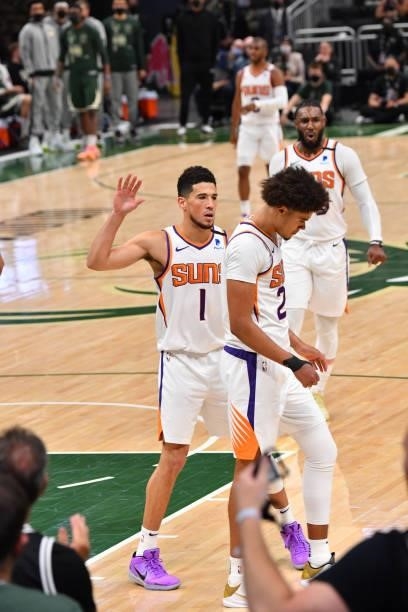 Cameron Johnson of the Phoenix Suns and Devin Booker of the Phoenix Suns react during Game Three of the 2021 NBA Finals on July 11, 2021 at Fiserv...