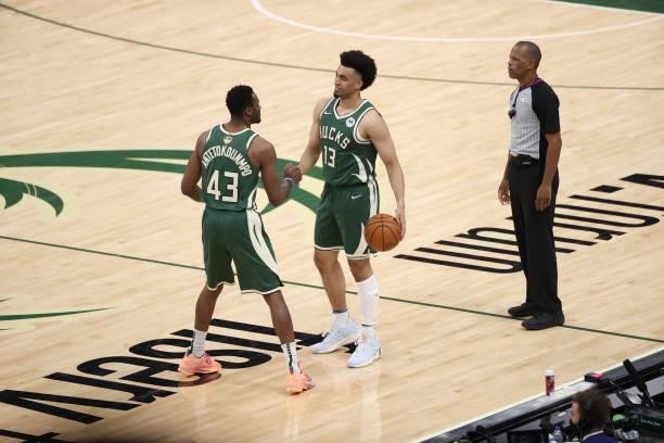Thanasis Antetokounmpo and Jordan Nwora of the Milwaukee Bucks hi-five after winning Game Three of the 2021 NBA Finals against the Phoenix Suns on...