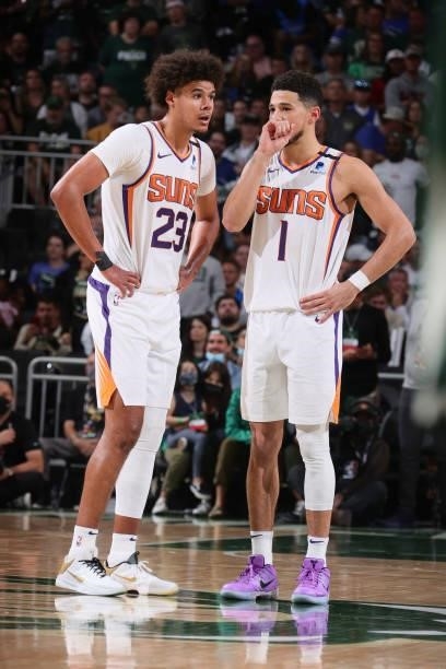 Cameron Johnson talks with Devin Booker of the Phoenix Suns during Game Three of the 2021 NBA Finals on July 11, 2021 at the Fiserv Forum Center in...