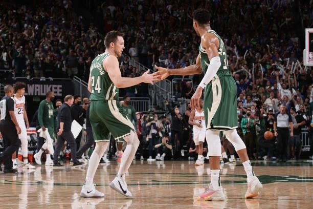 Pat Connaughton hi-fives Giannis Antetokounmpo of the Milwaukee Bucks during Game Three of the 2021 NBA Finals on July 11, 2021 at the Fiserv Forum...