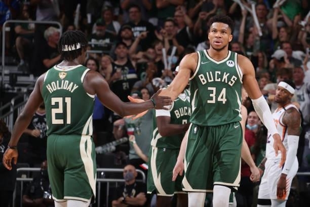 Giannis Antetokounmpo hi-fives Jrue Holiday of the Milwaukee Bucks during Game Three of the 2021 NBA Finals on July 11, 2021 at the Fiserv Forum...
