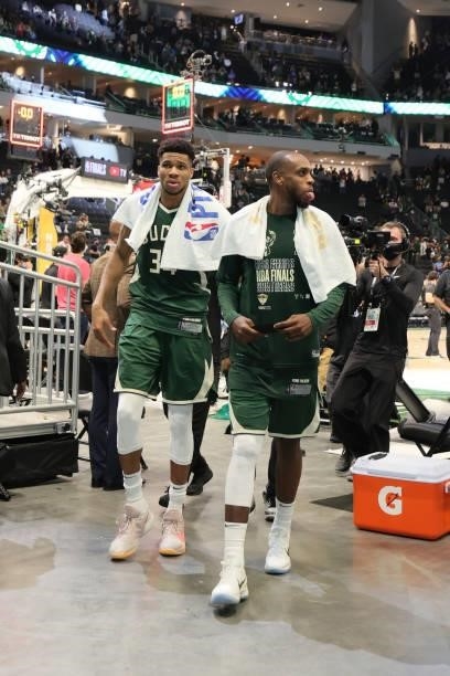 Giannis Antetokounmpo and Khris Middleton of the Milwaukee Bucks walk off of the court after the game against the Phoenix Suns during Game Three of...