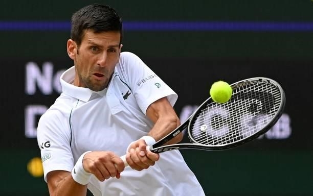 Serbia's Novak Djokovic returns to Italy's Matteo Berrettini during their men's singles final match on the thirteenth day of the 2021 Wimbledon...