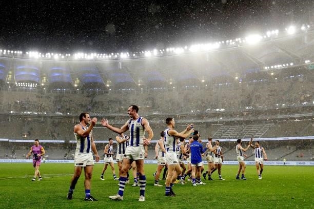 The Kangaroos celebrate after the teams win during the 2021 AFL Round 17 match between the West Coast Eagles and the North Melbourne Kangaroos at...