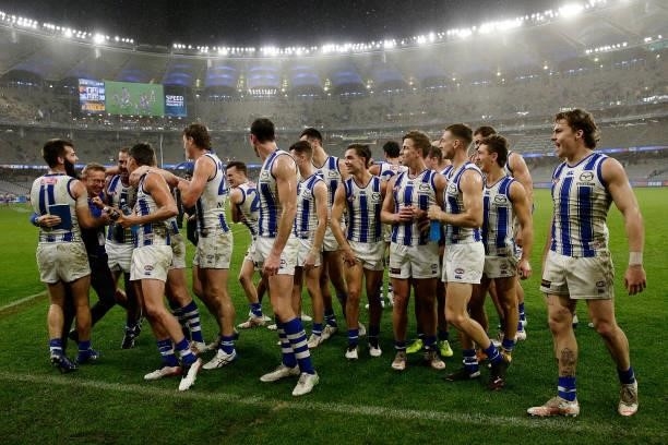 David Noble, Senior Coach of the Kangaroos celebrates with the team after the win during the 2021 AFL Round 17 match between the West Coast Eagles...