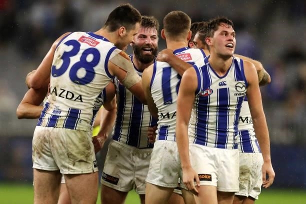 The Kangaroos celebrate after the teams win during the 2021 AFL Round 17 match between the West Coast Eagles and the North Melbourne Kangaroos at...