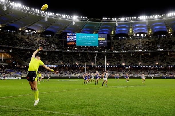 The boundary umpire throws the ball into play during the 2021 AFL Round 17 match between the West Coast Eagles and the North Melbourne Kangaroos at...