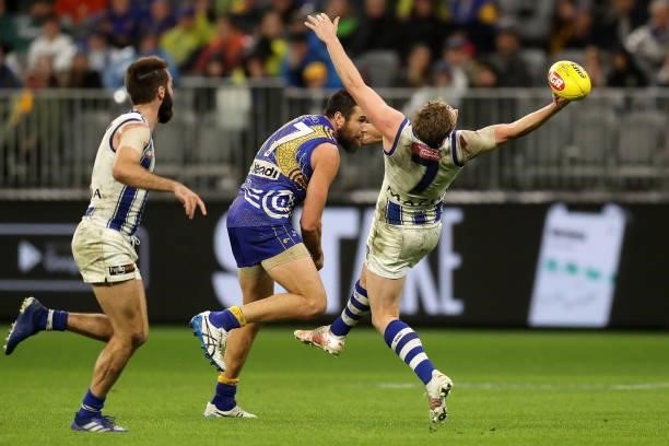 Jack Ziebell of the Kangaroos tries to mark under pressure from Josh J. Kennedy of the Eagles during the 2021 AFL Round 17 match between the West...