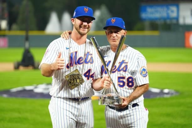 Pete Alonso of the New York Mets celebrates winning his second straight home run derby title with Mets Bench Coach Dave Jauss during the 2021...