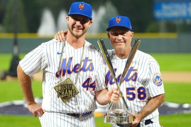 Pete Alonso of the New York Mets celebrates winning his second straight home run derby title with Mets Bench Coach Dave Jauss during the 2021...