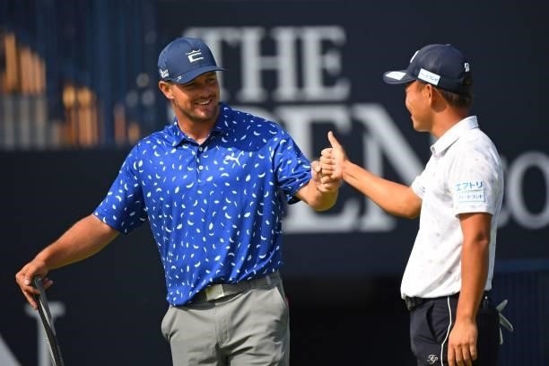 Golfer Bryson DeChambeau and Japan's Ryosuke Kinoshita bump fists after their rounds on the 18th green during practice for The 149th British Open...
