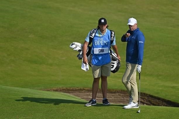 Golfer Stewart Cink chats with his caddie, his son Reagan, during a practice round for The 149th British Open Golf Championship at Royal St George's,...