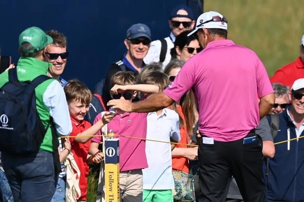 Ireland's Padraig Harrington takes his prize of a golf ball after playing "rock, paper, scissors