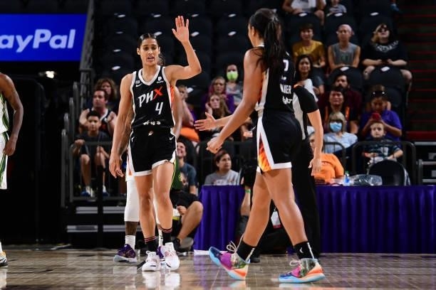 Skylar Diggins-Smith hi-fives Megan Walker of the Phoenix Mercury during the game against the Seattle Storm on July 9, 2021 at Phoenix Suns Arena in...