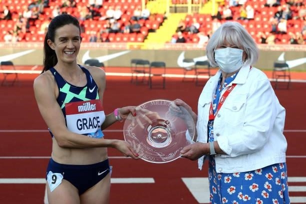 Kate Grace of The USA is presented with the trophy after winning the final of the women's Millicent Fawcett Mile during the Muller British Grand...