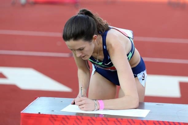 Kate Grace of The USA signs a book after winning the final of the women's Millicent Fawcett Mile during the Muller British Grand Prix, part of the...