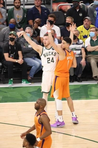 Pat Connaughton of the Milwaukee Bucks shoots the ball during the game against Devin Booker of the Phoenix Suns during Game Four of the 2021 NBA...