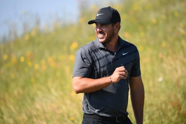 Golfer Brooks Koepka smiles as he leaves the 7th tee during his first round on day one of The 149th British Open Golf Championship at Royal St...