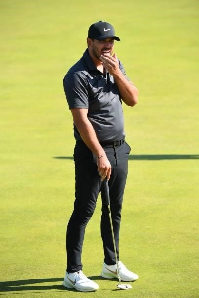Golfer Brooks Koepka reacts to missing his putt on the 6th green during his first round on day one of The 149th British Open Golf Championship at...