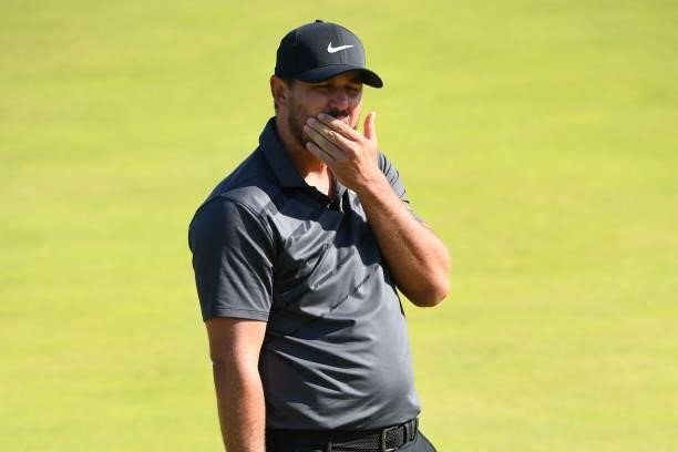 Golfer Brooks Koepka reacts to missing his putt on the 6th green during his first round on day one of The 149th British Open Golf Championship at...