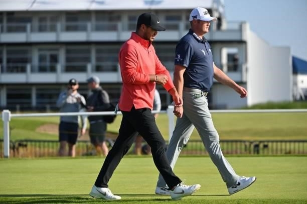 Golfer Brooks Koepka and US golfer Jason Kokrak walk from the 1st tee during his first round on day one of The 149th British Open Golf Championship...