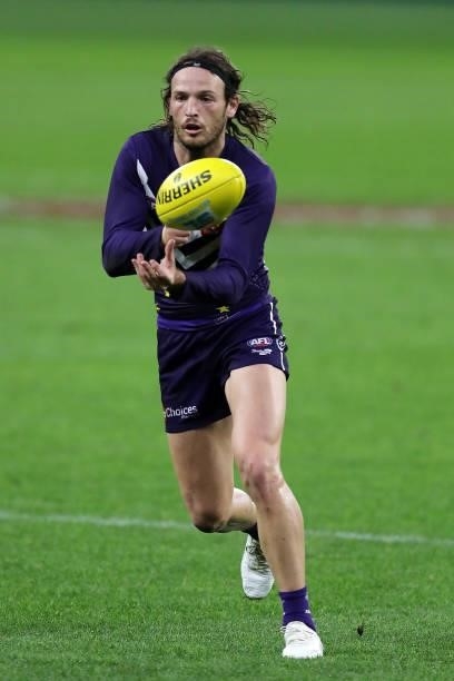 James Aish of the Dockers handpasses the ball during the 2021 AFL Round 18 match between the Fremantle Dockers and the Geelong Cats at Optus Stadium...